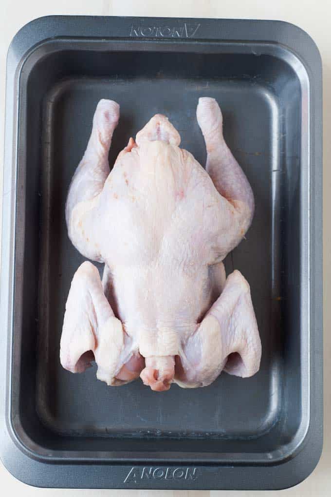 step by step chicken roasting image step 1: raw chicken in roasting pan.