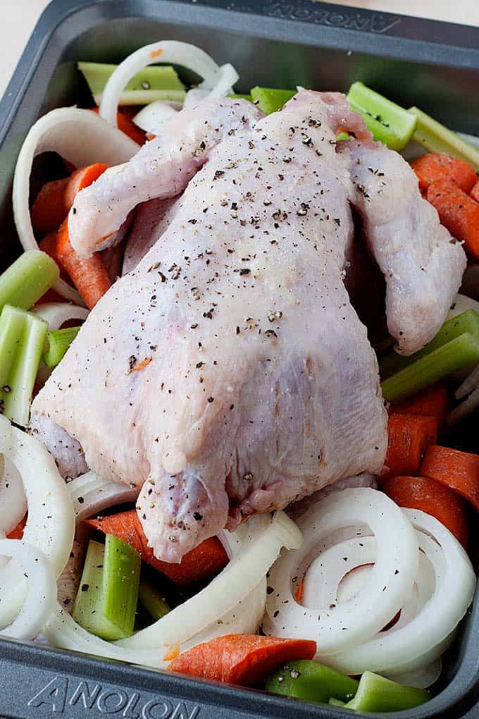 step by step roasting chicken images step two: seasoned whole raw bird placed over raw vegetables in a roasting pan