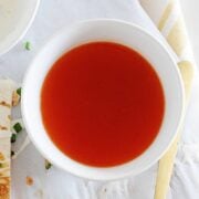 Overhead view of buffalo sauce in a white bowl