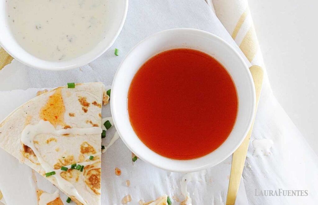 Overhead view of buffalo sauce in a white bowl