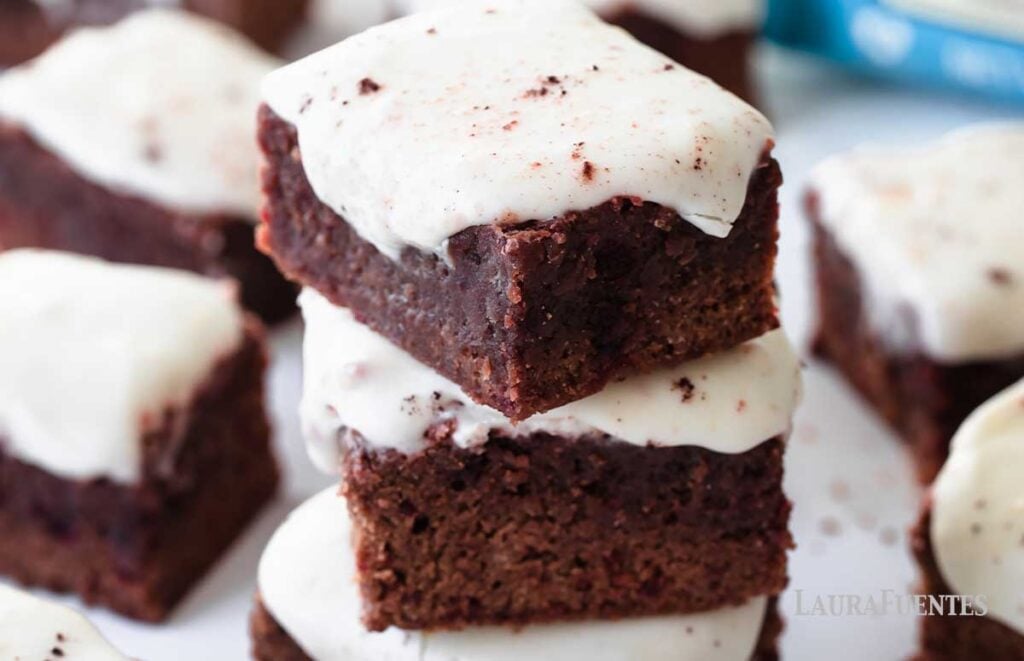 image: stack of three red velvet chocolate brownies with frosting