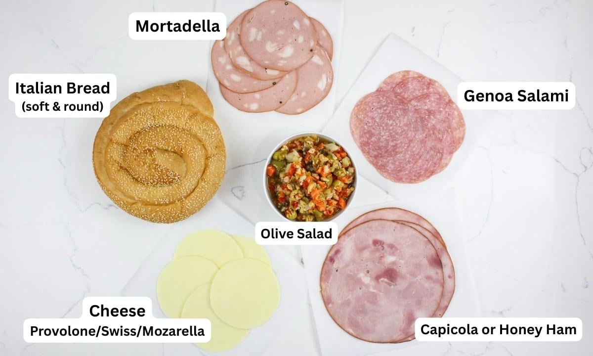 overhead view of ingredients with labels needed to make a new orleans muffuletta
