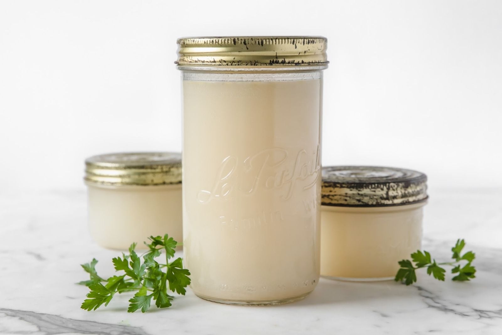 three jars with homemade chicken broth