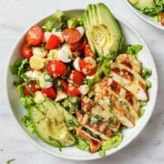 top view of caprese salad topped with Blackened chicken and avocado