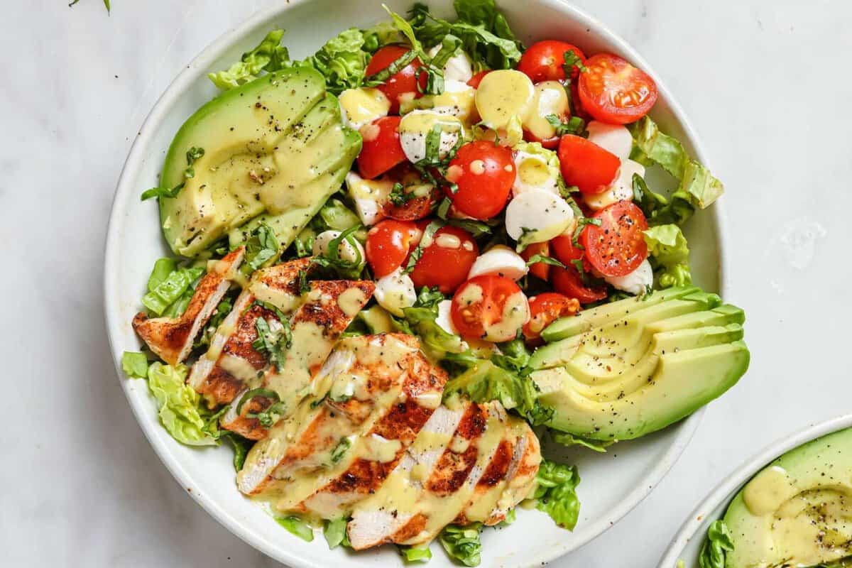top view of caprese salad topped with Blackened chicken and avocado