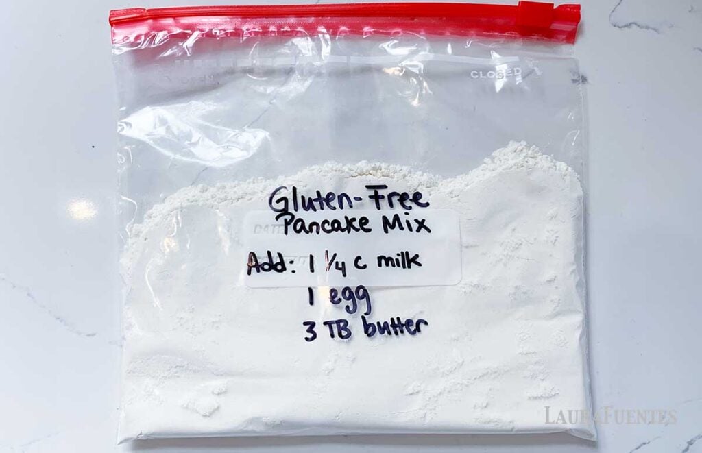 image: large zip bag full of pancake mix. Written on the bag in black marker "Gluten-Free Pancake Mix Add 1 ¼ c milk, 1 egg, 3TB butter." 