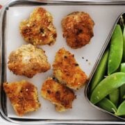 lunchbox with six chicken nuggets and veggies on the side.