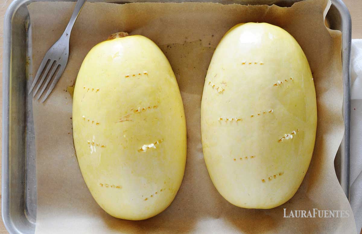 two spaghetti squash halves poked for baking
