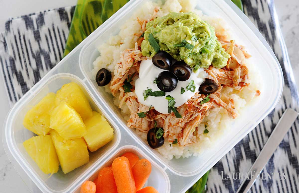 chicken burrito bowl in a lunch container with pineapple and carrots