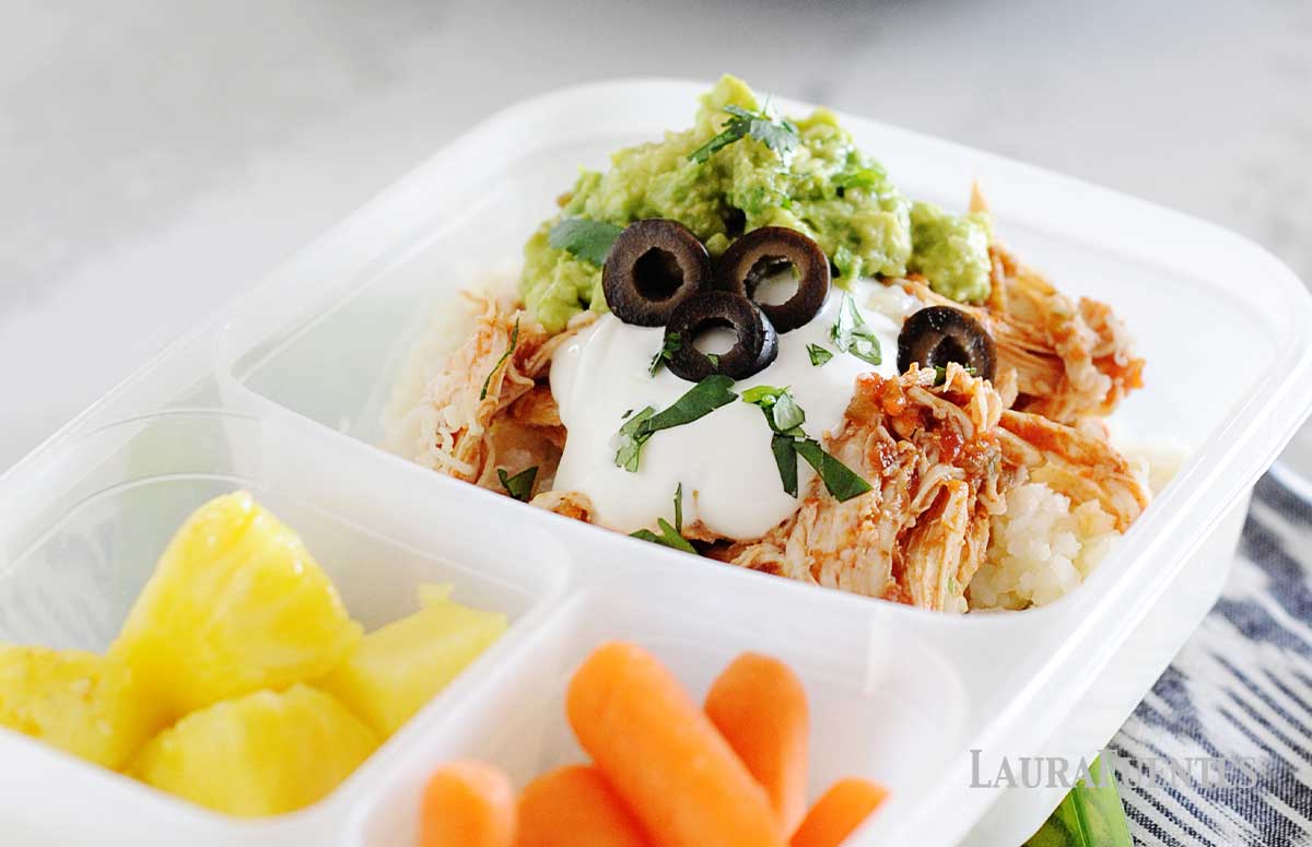 chicken burrito bowl in a lunch container with pineapple and carrots