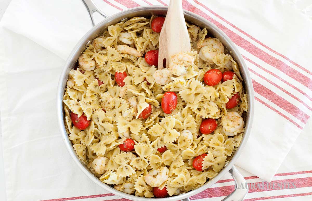 bowtie pasta in a skillet with shrimp and grape tomatoes