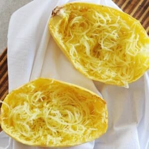 two spaghetti squash halves with squash made into "noodles" inside the skin.