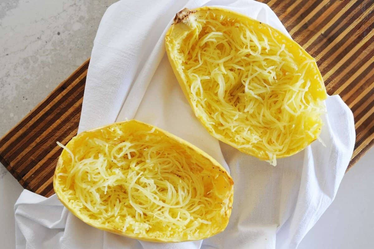 two spaghetti squash halves with squash made into "noodles" inside the skin.