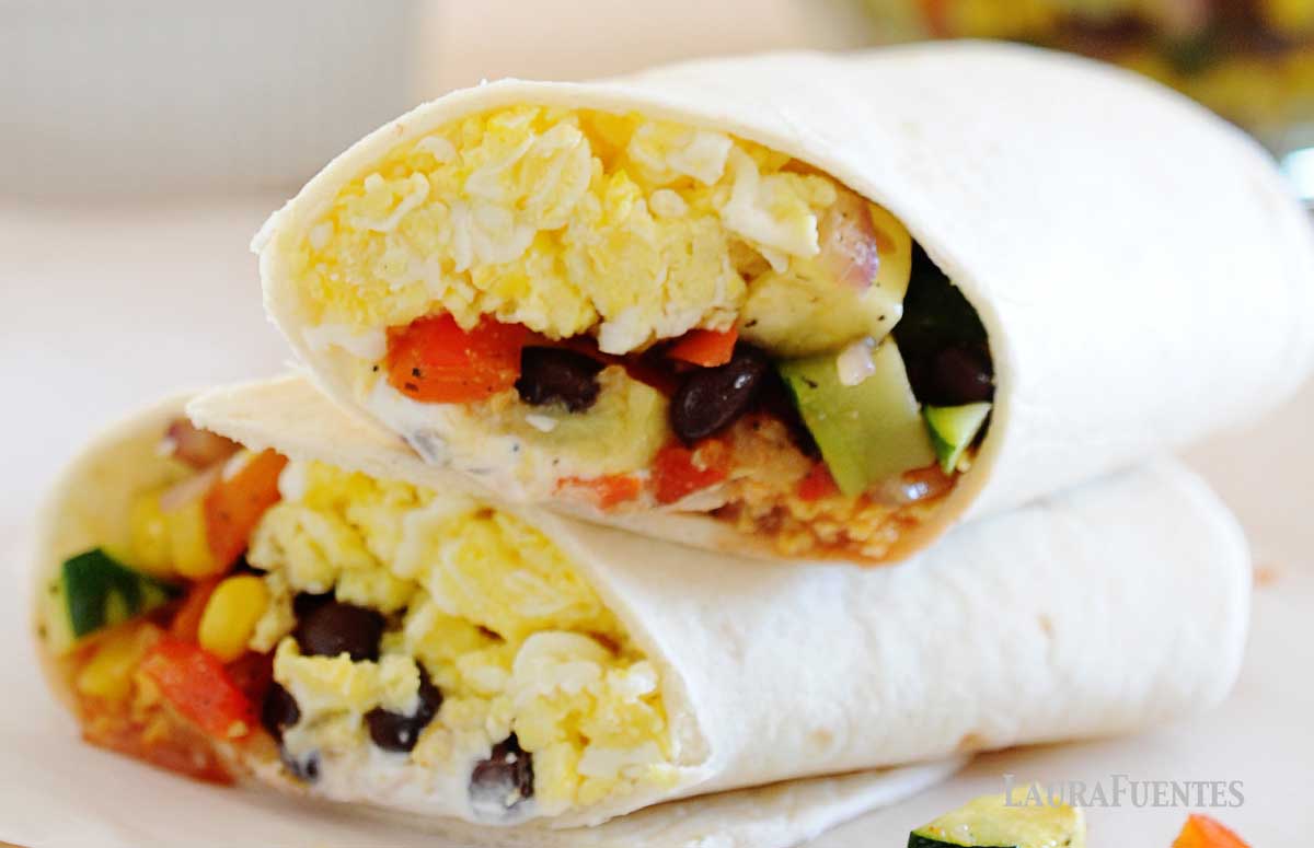 two halves of a veggie breakfast burrito on a countertop