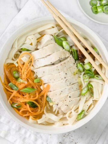 top view of chicken udon soup in a bowl with chopsticks