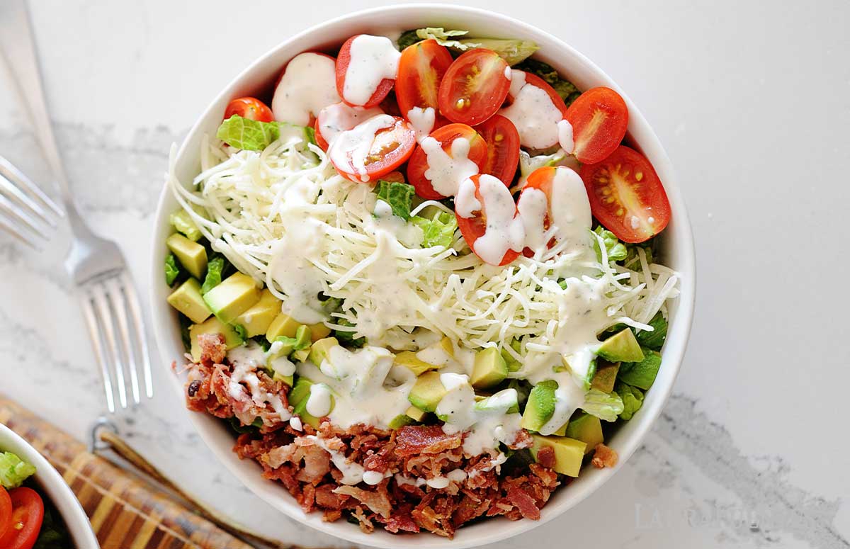 huge blt salad with dressing in a bowl