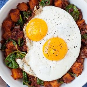 healthy breakfast hash topped with two fried eggs