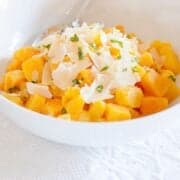 a bowl of savory butternut squash cubes with Parmesan