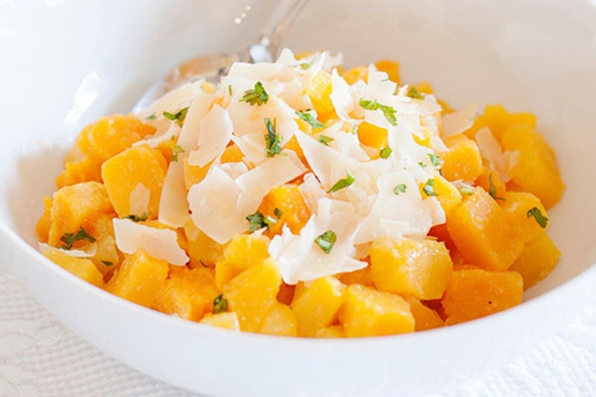 a bowl of savory butternut squash cubes with Parmesan