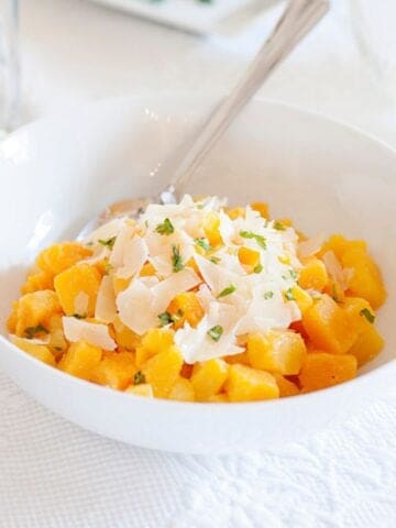 a bowl of savory butternut squash cubes with Parmesan