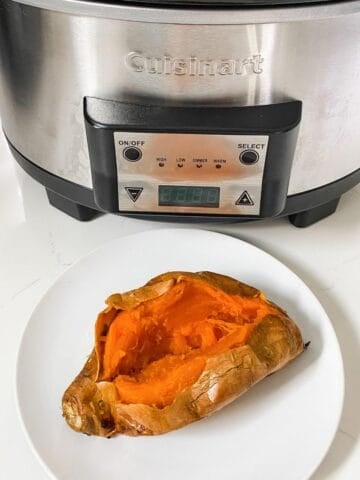 baked sweet potato on a plate in front of slow cooker