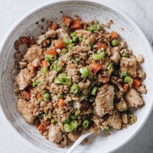 overhead view of white bowl filled with chicken fried cauliflower rice