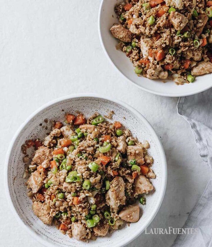 two bowls filled with chicken fried (cauliflower) rice.