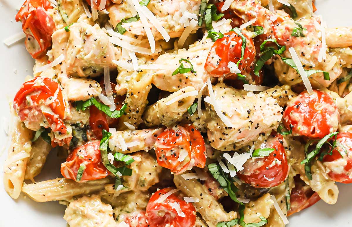 salmon and tomato pasta topped with shredded parmesan cheese