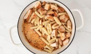 combining the chicken pasta and sauce in a skillet