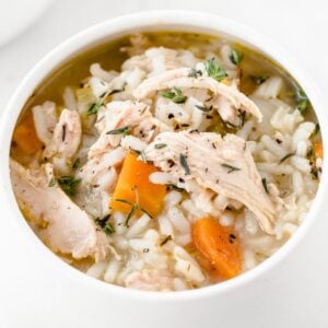 a white bowl of chicken and rice soup