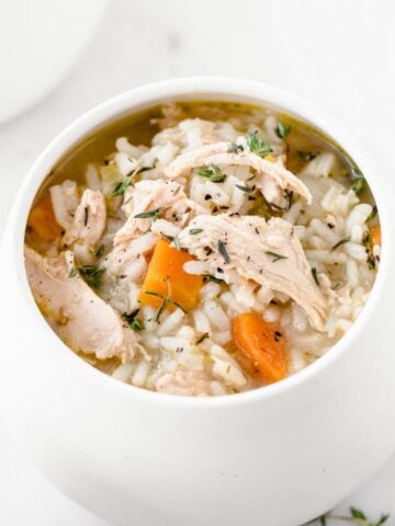 a white bowl of chicken and rice soup
