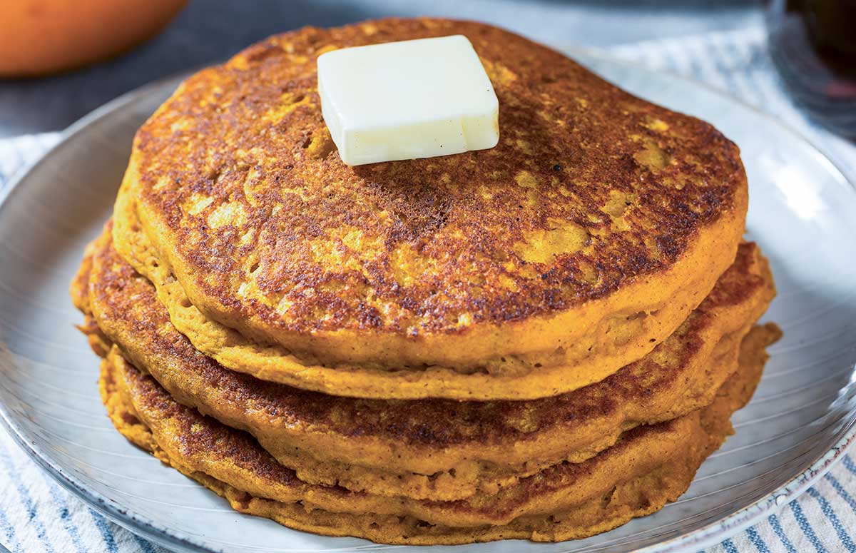 stack of healthy pumpkin pancakes made with oatmeal (oats) topped with a pat of butter