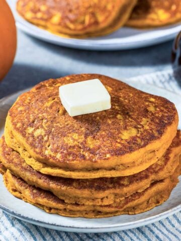 stack of healthy pumpkin pancakes made with oatmeal (oats) topped with a pat of butter