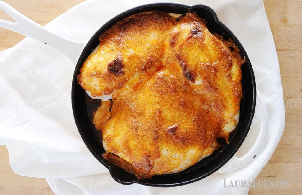chicken breasts in a skillet, coated with sauce and freshly baked.