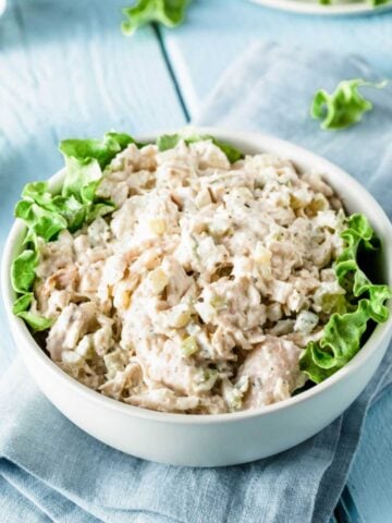 a bowl of turkey salad with lettuce on the sides