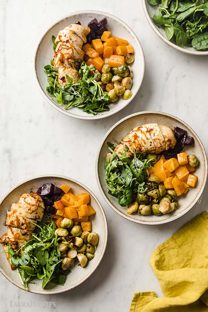 three plates of sliced chicken, greens and roasted Fall vegetables