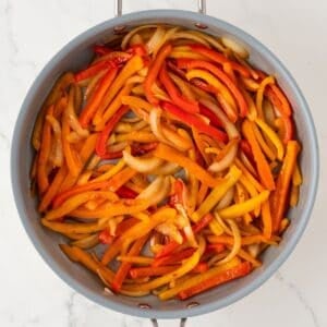 overhead view of roasted bell peppers and onions in a skillet