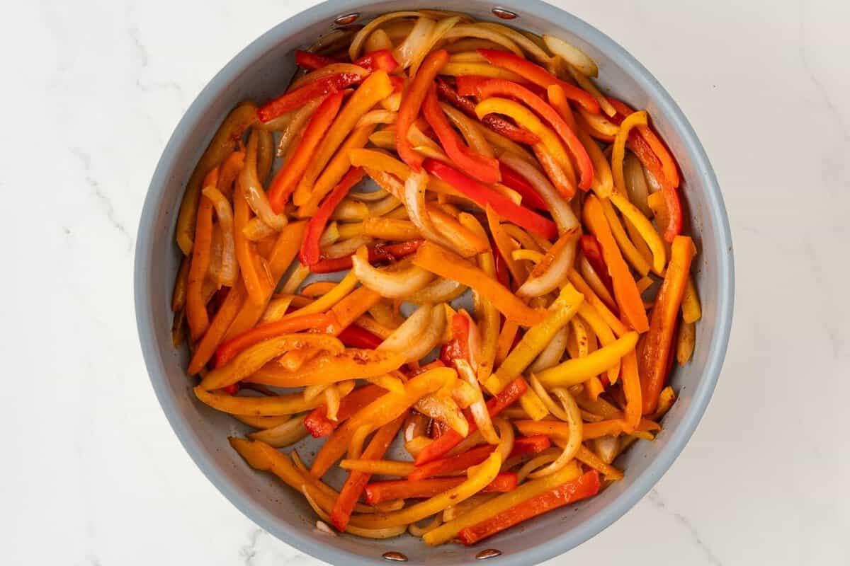overhead view of roasted bell peppers and onions in a skillet