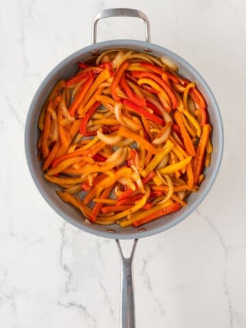 overhead view of roasted bell peppers and onions in a skillet
