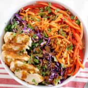 top view of a bowl of thai chicken pasta salad with carrots, bell peppers and cabbage