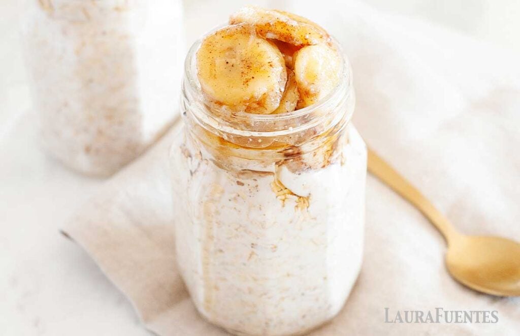 image: wide view of two glass jars of overnight oats with banana