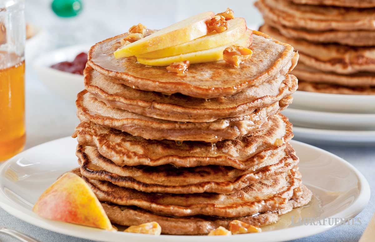 stack of whole wheat pancakes topped with sliced apples