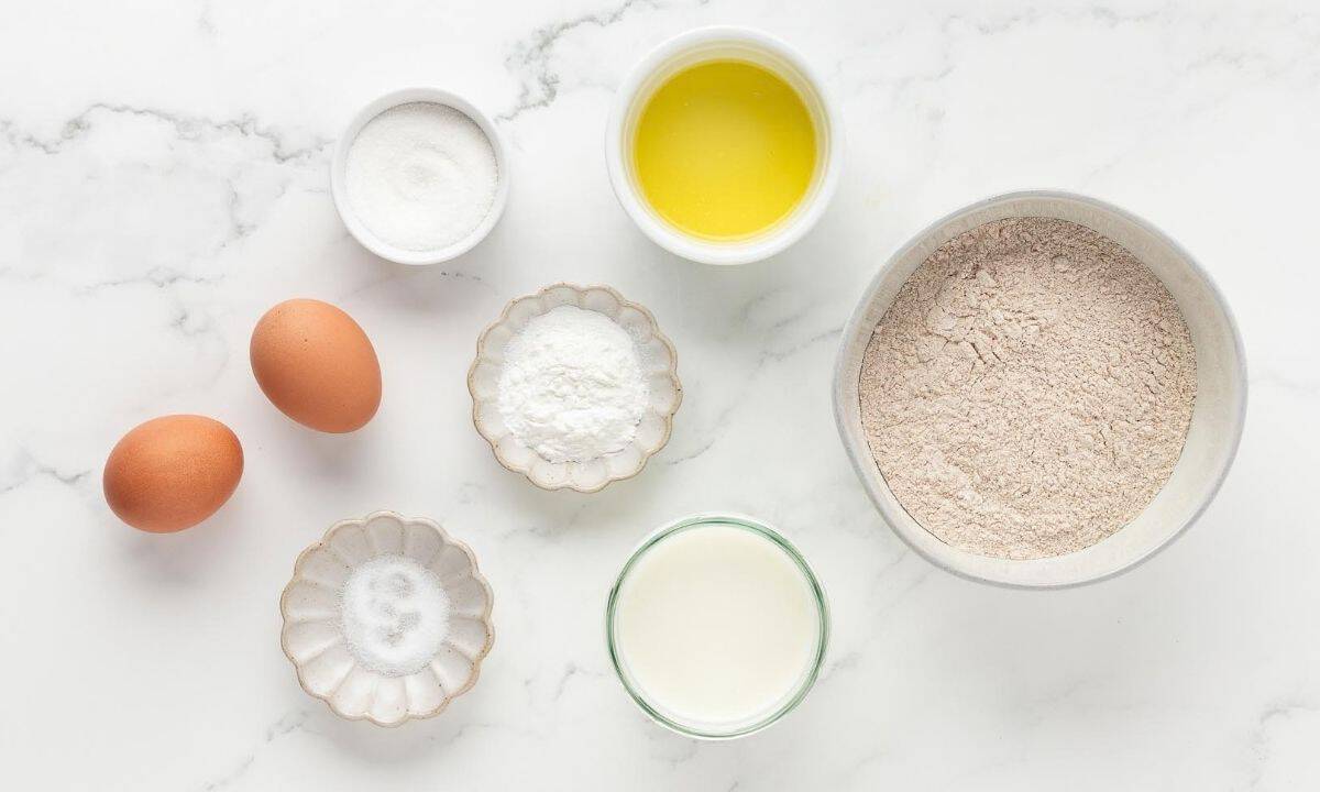 ingredients for whole wheat pancakes: whole wheat flour, melted butter, milk, eggs, sugar, salt, and baking powder