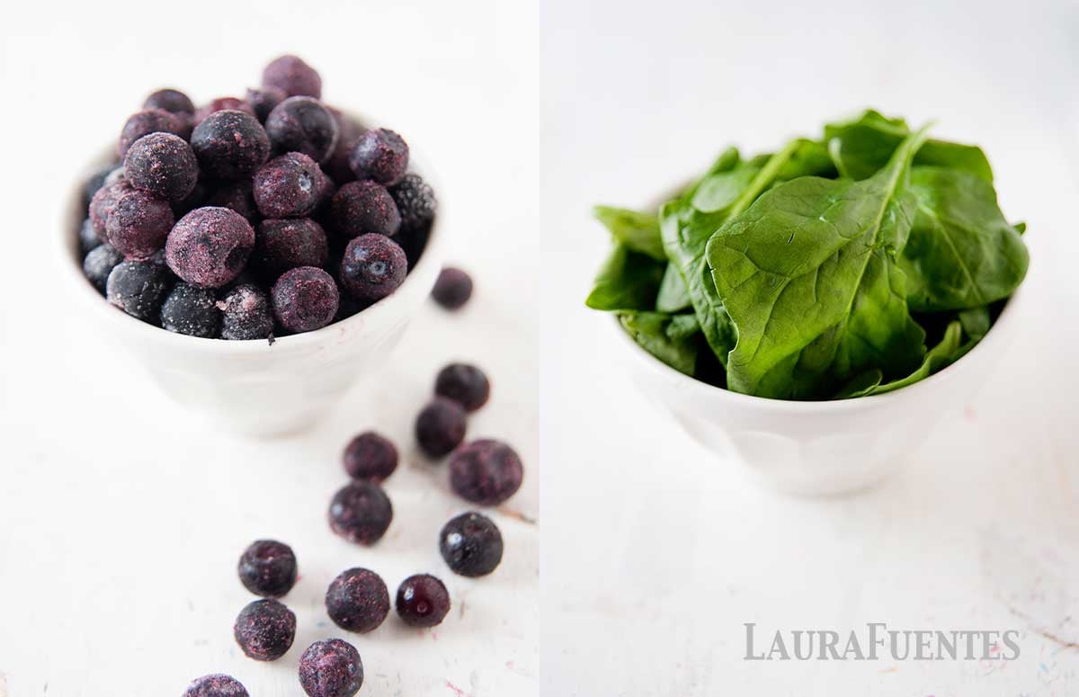 blueberries in a bowl and fresh spinach leaves in a bowl side by side