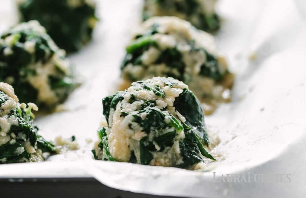 spinach balls, shaped and on a baking sheet