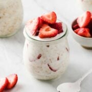overnight oats jar filled with oats, milk, yogurt, and strawberries