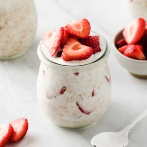 overnight oats jar filled with oats, milk, yogurt, and strawberries