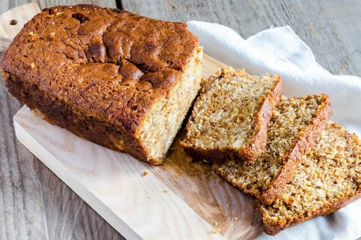 a loaf of applesauce bread on a cutting board with several slices