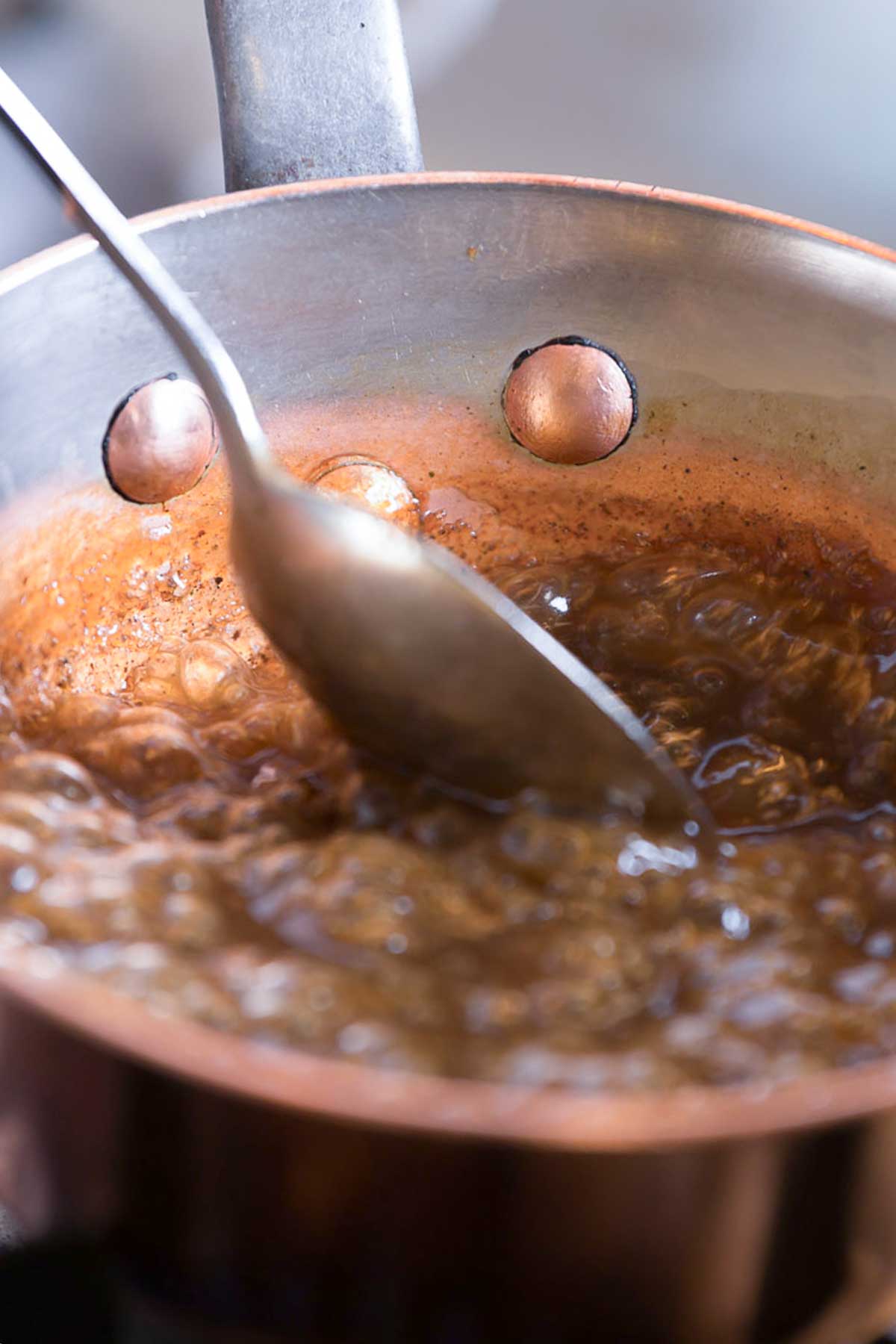 small saucepan with brown sugar and water simmering to make pancake syrup