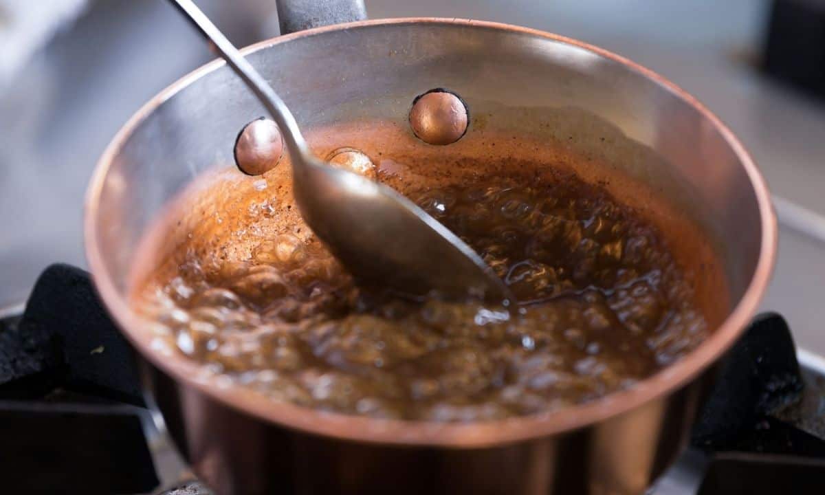 small saucepan with brown sugar and water simmering to make pancake syrup